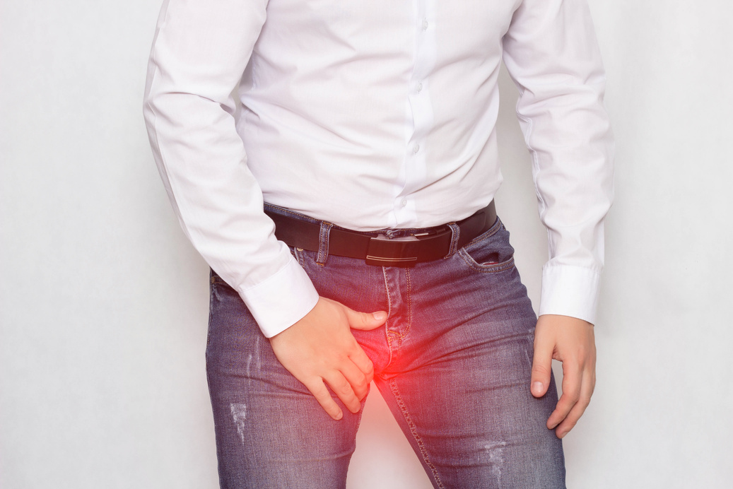 A Man on a White Background in a White Shirt Holding on to His Groin He Has Pain and Varicocele of the Spermatic Cord, a Problem, Varicose Veins